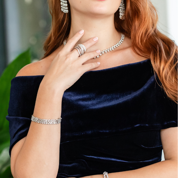 woman wearing silver diamond bracelets, diamond wedding ring, diamond earrings and a shining diamond necklace