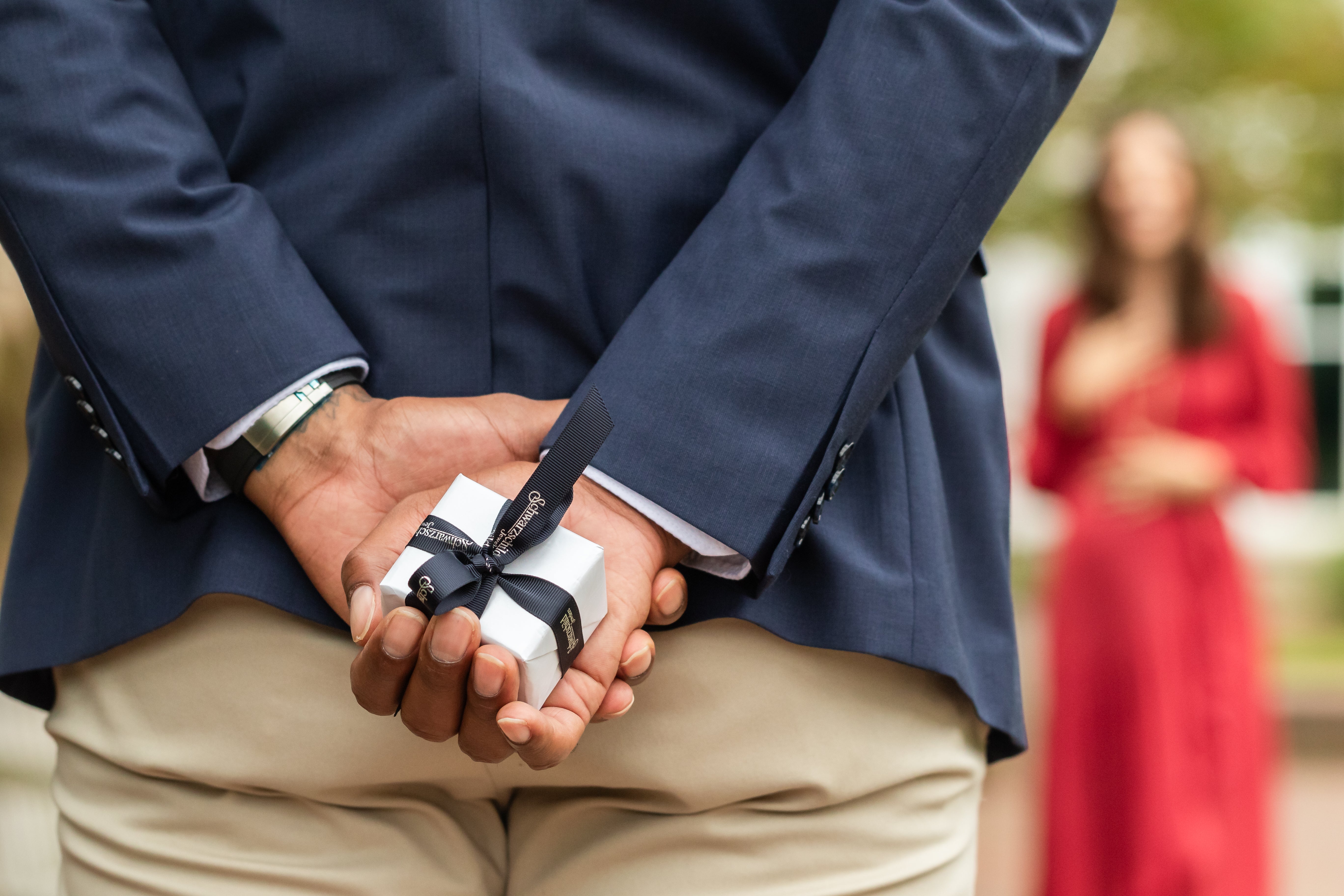 Man proposing to his girlfriend during the Christmas season, presenting a ring in an elegant box