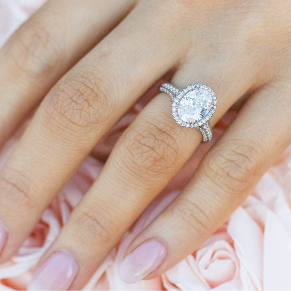 a close uo image of a woman wearing an oval engagement ring