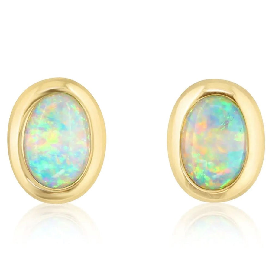 A pair of oval-shaped Australian opal bezel set stud earrings in 14K yellow gold.