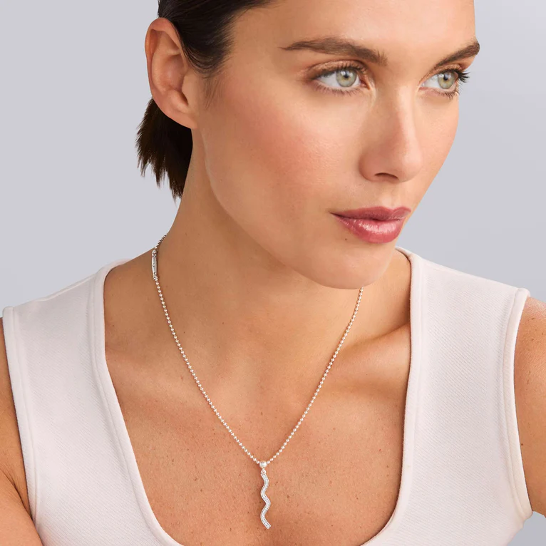 Woman wearing a silver necklace with a white background