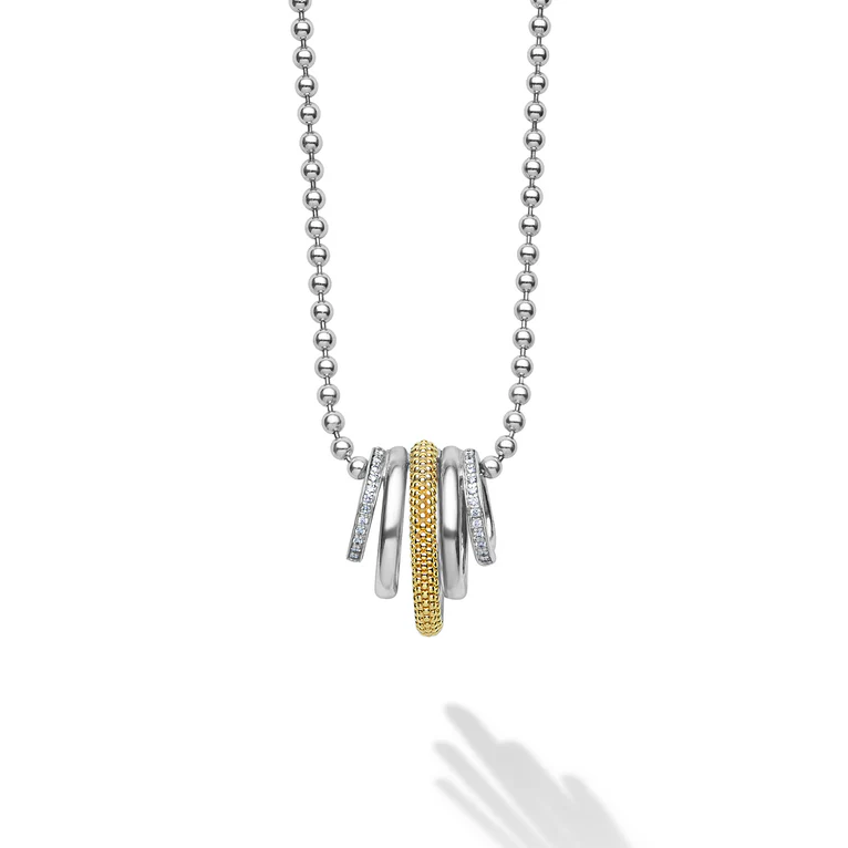 Necklace with a pendant featuring three rings, two silver and one gold, on a white background.