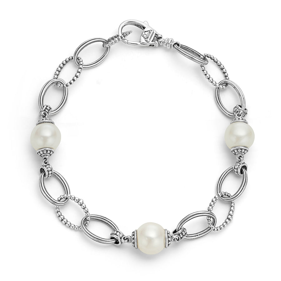 A sterling silver bracelet with smooth oval links and lustrous pearl accents.