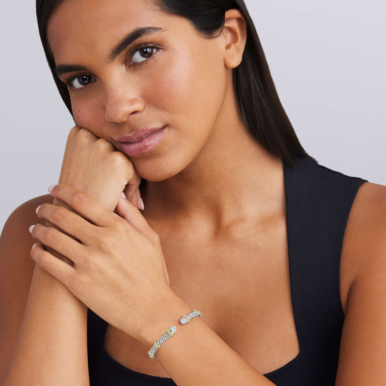 Woman wearing a bracelet on a plain background