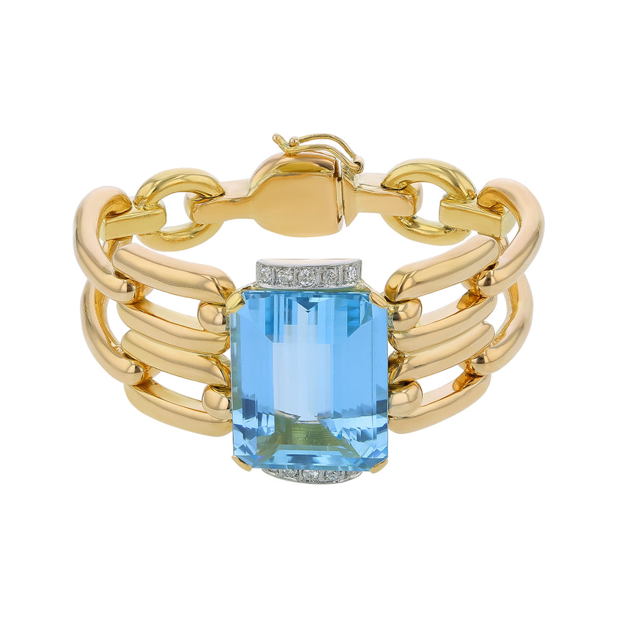 Gold bracelet with a blue gemstone on a white background