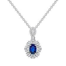 0.60ct Oval Sapphire, 0.34ct Round and Tapered Baguette Diamond Halo Pendant in 18K White Gold, 18" chain